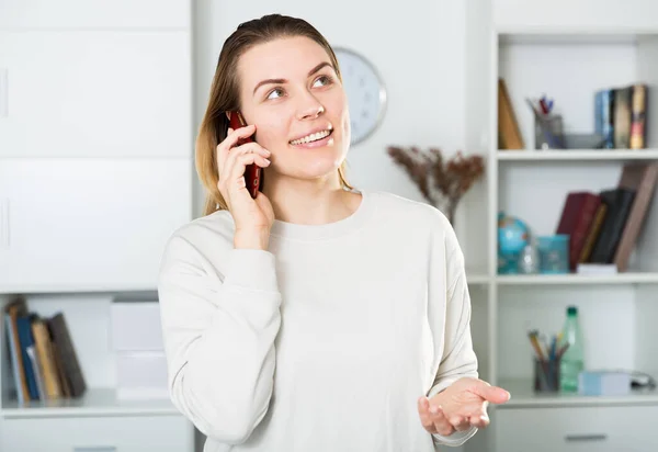 Jeune femme est assis avec smartphone et souriant — Photo