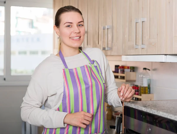 Huisvrouw staat en poseert in de keuken — Stockfoto