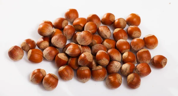 Heap of raw hazelnuts on white — Stock Photo, Image