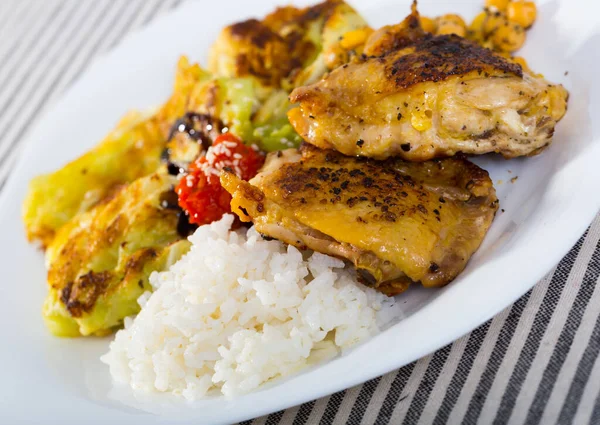 Tasty chicken thighs with cabbage leaves in batter, garbanzo and rice — Stock Photo, Image