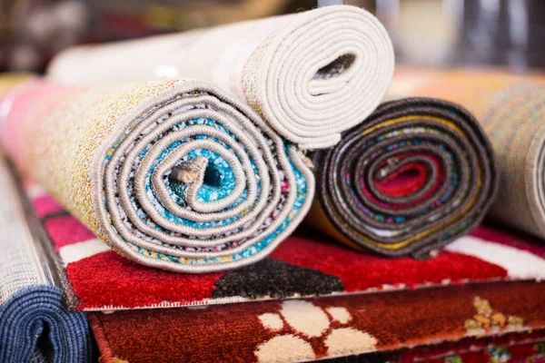 Alfombras de diferentes colores en pila en la tienda de alfombras —  Fotos de Stock