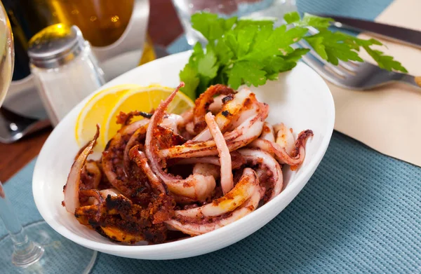 Délicieux calmar cuit ou pieuvre tentacules avec citron et persil sur une assiette — Photo