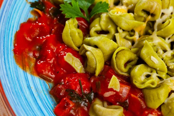 Closeup of spinach tortellini with vegetable sauce and cheese — Stock Photo, Image