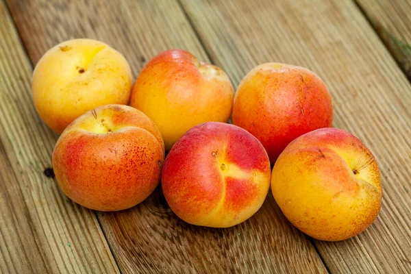 Afbeelding van rijpe sappige abrikozen op houten tafel in keuken — Stockfoto