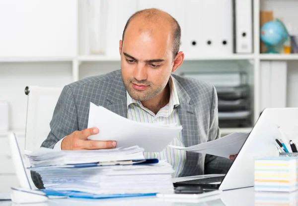 Homme d'affaires en chemise visualisant des documents à la table — Photo