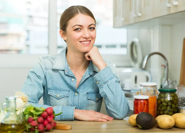 Sorrindo dona de casa cozinhar jantar na cozinha em casa — Fotografia de Stock