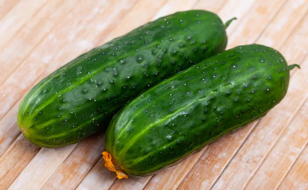 Ripe juicy cucumbers on wooden table closeup — Stock Photo, Image