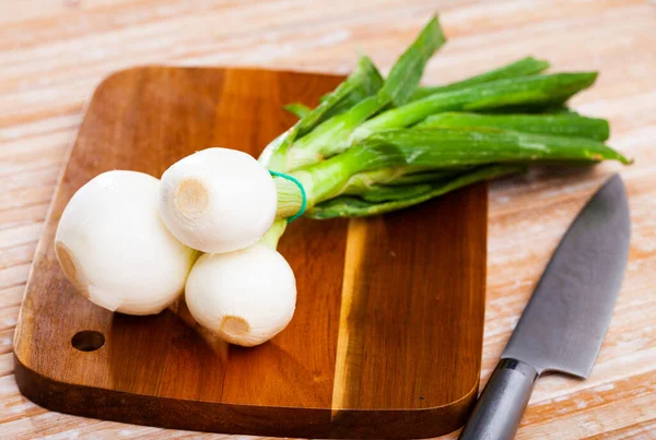 Cebolla de primavera sobre mesa de madera, preparación de alimentos —  Fotos de Stock
