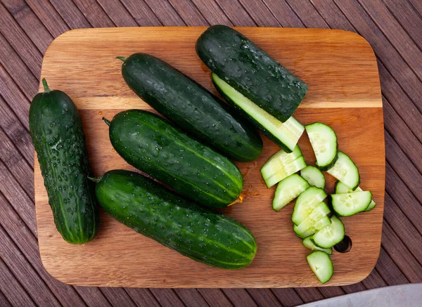 Pepinos fatiados na mesa de madeira, ingredientes alimentares — Fotografia de Stock