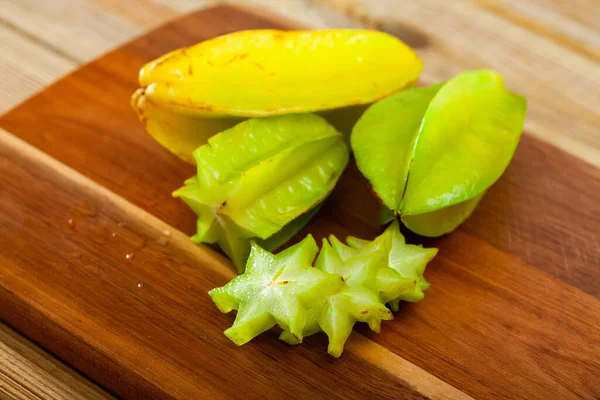 Ganze und in Scheiben geschnittene Früchte, frische Karambolage auf dem Tisch. Gesunde vegetarische Zutat — Stockfoto