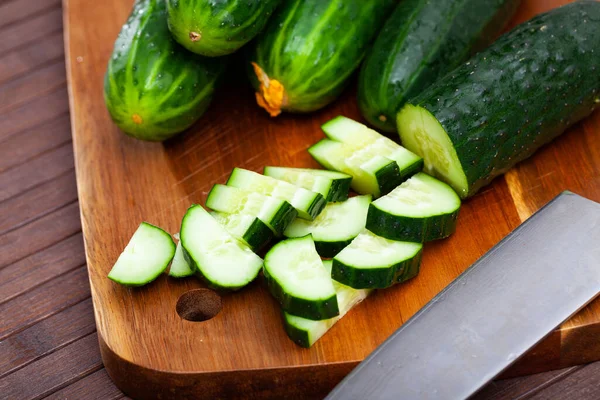 Ripe green cut cucumbers on wooden background — Stock Photo, Image
