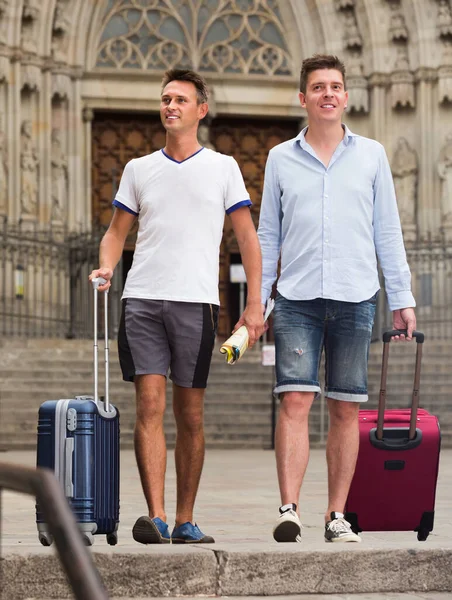 Dois homens viajantes em shorts com bagagem andando — Fotografia de Stock