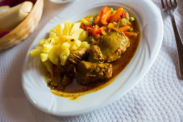 Image of baked pork cheeks in sauce with potatoes and vegetables