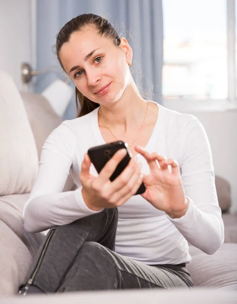 Hemmafru använder sin mobiltelefon — Stockfoto