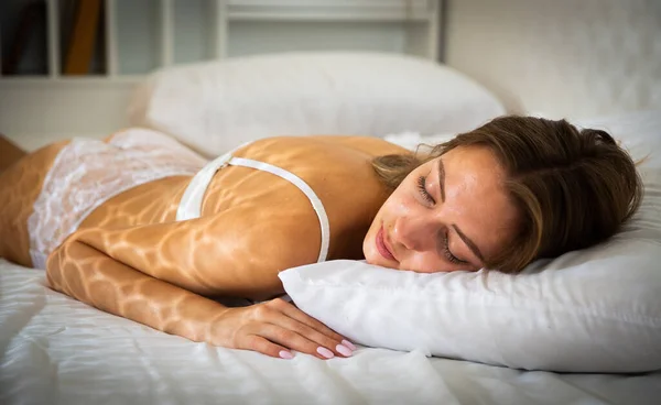 Porträtt av blond flicka med långt hår sover i sängen — Stockfoto