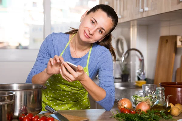 Woman looking for recipe using phone — Stock Photo, Image