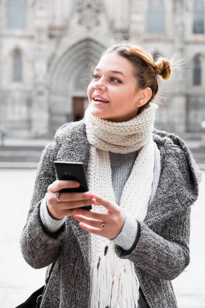 Dívka pomocí mobilního telefonu v šále — Stock fotografie