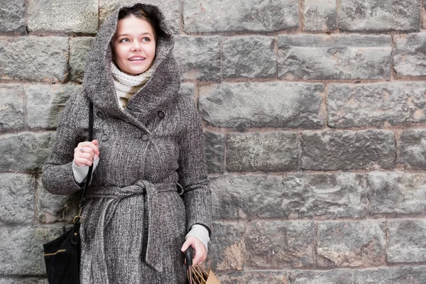 Ragazza in cappuccio in piedi vicino al muro di pietra — Foto Stock