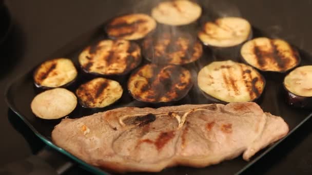 Processus de friture de côtelette d'épaule de porc avec des aubergines tranchées sur poêle à frire — Video