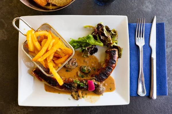 Salsichas de porco com cogumelos, batatas fritas e alface — Fotografia de Stock