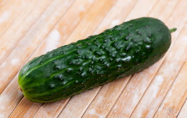 Many ripe juicy cucumbers on wooden surface — Stock Photo, Image