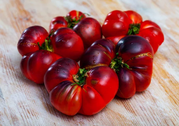 Muchos tomates azules rojos en la superficie de madera — Foto de Stock