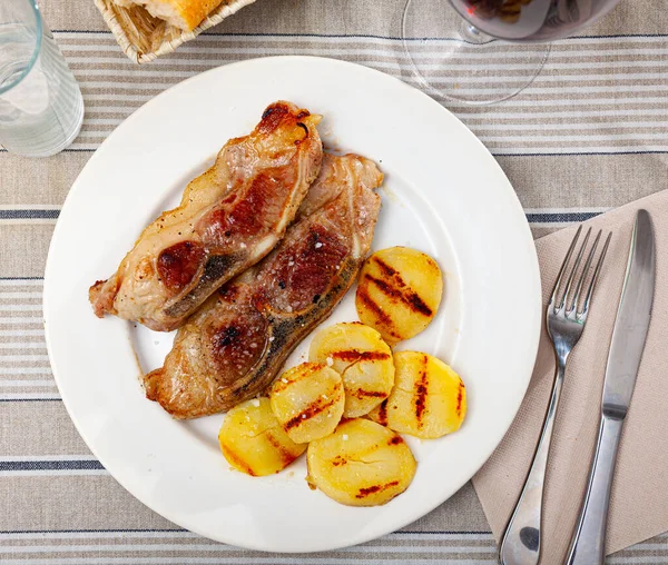 Imagem de porco grelhado com batatas servidas no prato — Fotografia de Stock