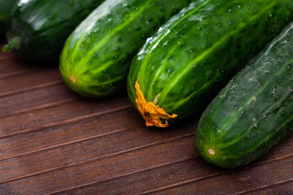 Fresh green juicy cucumbers on wooden table — Stock Photo, Image