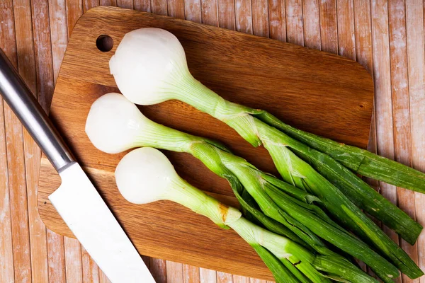 Delicate white onion with tops closeup on table — Stock Photo, Image