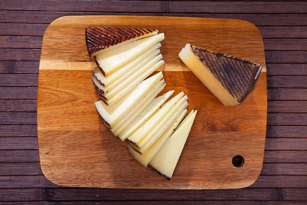 Cunha cortada de queijo de ovelha envelhecido em tábua de madeira — Fotografia de Stock