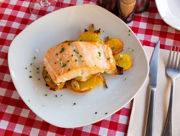 Dish of tasty baked salmon with onion and potatoes — Stock Photo, Image