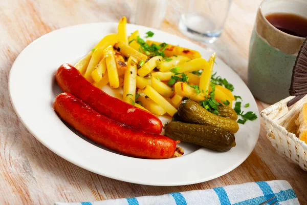 Embutidos a la parrilla con papas fritas y pepinillos — Foto de Stock