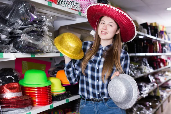 Mujer elegir tocados divertidos en la tienda —  Fotos de Stock