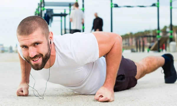 Mann macht Liegestütze auf Sportplatz — Stockfoto