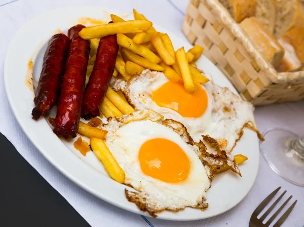 Huevos con chistorra. Rántotta kolbásszal és burgonyával. — Stock Fotó