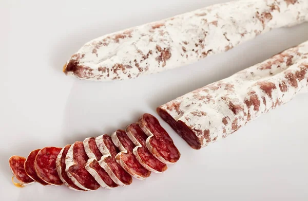 Close-up de salsichas fuet espanhol temperadas em fundo branco — Fotografia de Stock