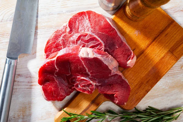 Carne crua de bife em uma placa de madeira — Fotografia de Stock