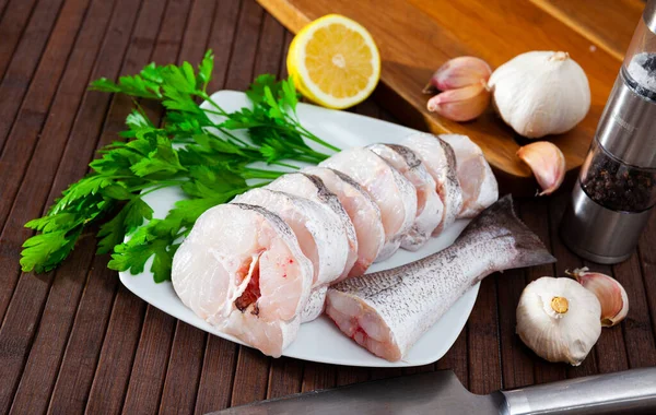 Steaks of raw walleye pollock with condiments and greens — Stock Photo, Image