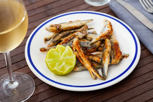 Fried anchovies served with slice of lemon — Stock Photo, Image