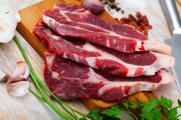 Filé de carne crua com cebola e pimenta pronto para cozinhar na mesa — Fotografia de Stock