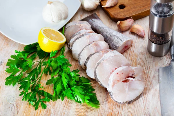 Raw hake sliced on cutting board — Stock Photo, Image