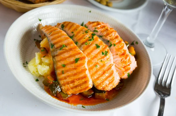 Sabroso filete de salmón a la parrilla en salsa con pimienta y limón en el plato — Foto de Stock