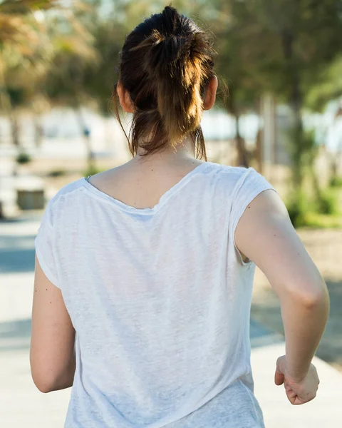 Donna adulta in nero T-shirt sta facendo jogging la schiena — Foto Stock