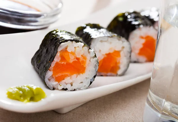 Maki rolls with salmon served with wasabi and soy sauce on white plate — Stock Photo, Image
