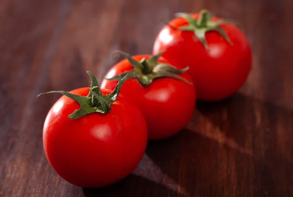 Rode tomaten op houten tafel in de keuken — Stockfoto