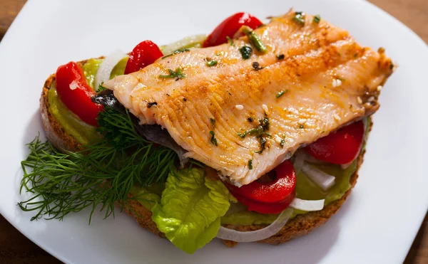 Bread with trout fillet, guacamole, vegetables — Stock Photo, Image