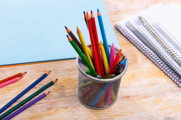 Lápices de madera multicolores en el escritorio con papeles y cuadernos —  Fotos de Stock