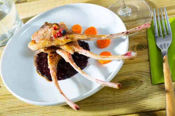 Baked lamb rack of ribs with carrots and sauce