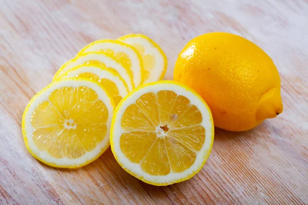 Nakrájené citrony na dřevěný stůl — Stock fotografie