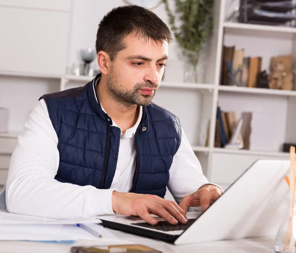 Бизнесмен в рубашке, работающий с ноутбуками и документами — стоковое фото